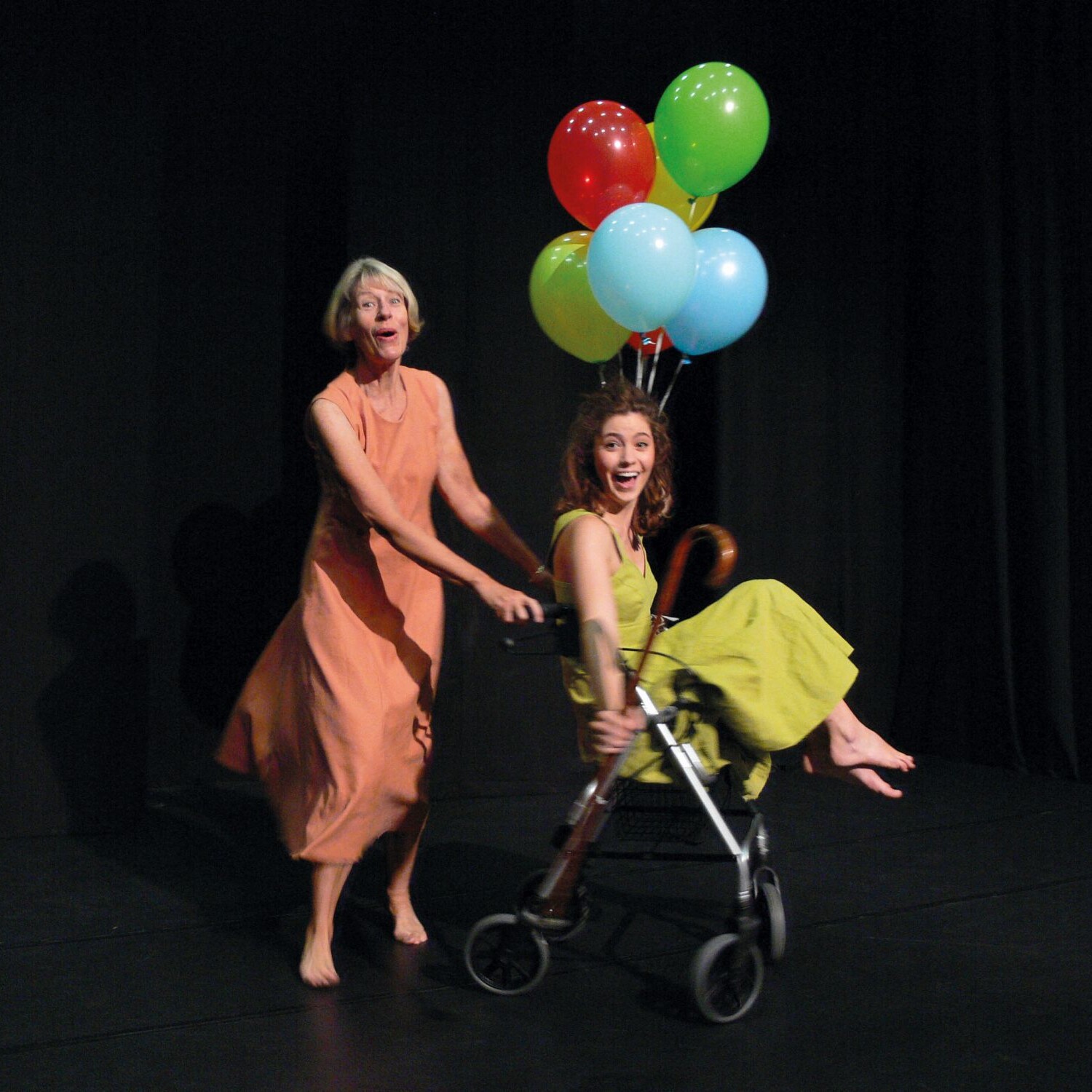 Teatro Piccolo: CORPUS DELICTI Szene. Frau schiebt andere im Rollator mit Ballons. Corpus-delicti-2017.