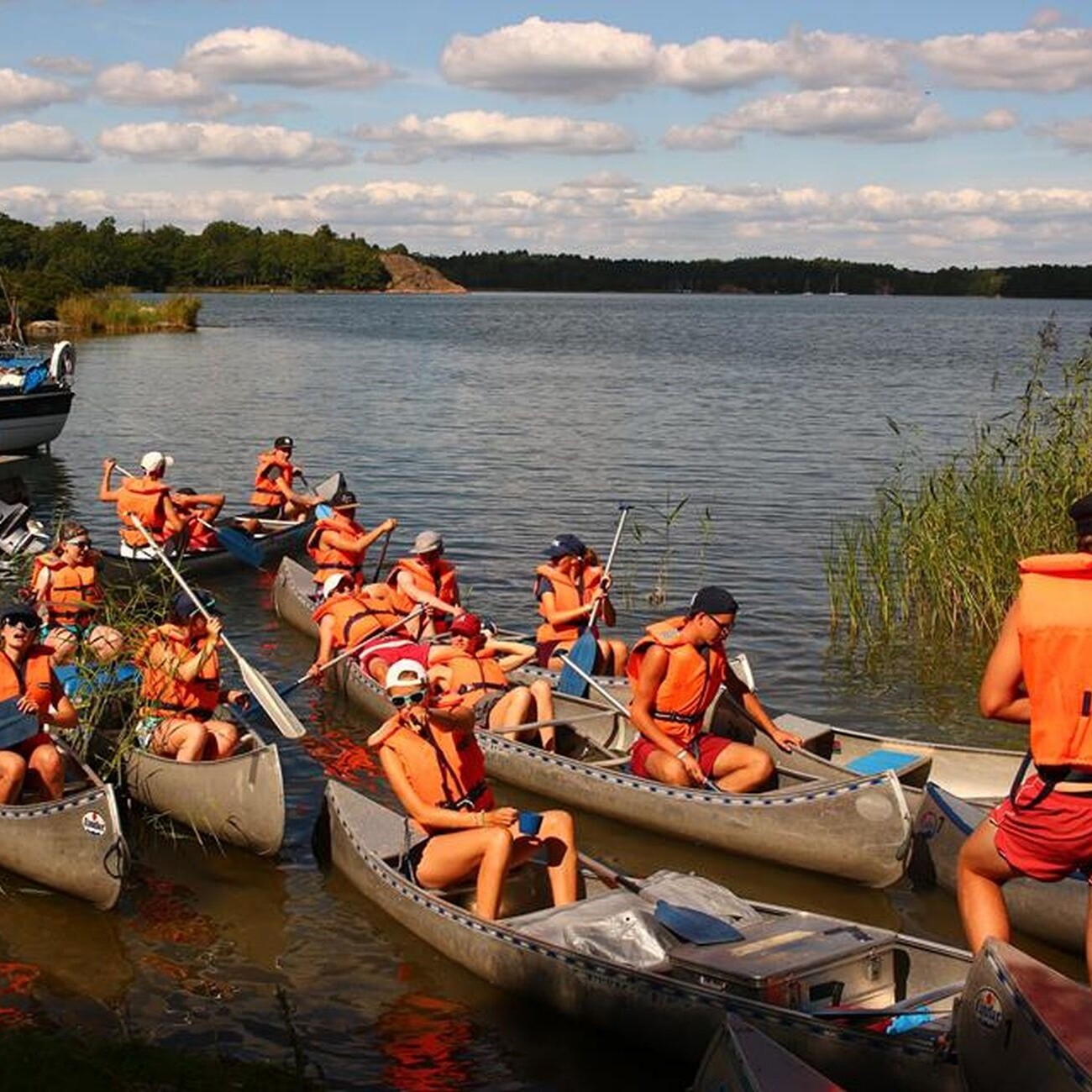 Unser Sommer 2018: Gruppe paddelt in Kanus auf dem See, Spaß und Abenteuer im Sommerurlaub.
