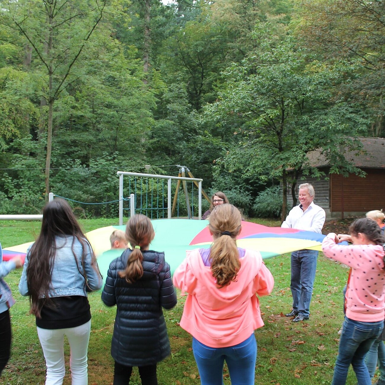 Waldheim FeuerbTal: Kinder spielen mit Fallschirm im Grünen. Wald, Spaß, Aktivität. Willkommen zurück!